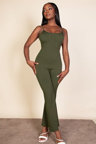 Woman wearing a green ribbed sleeveless wide leg jumpsuit with spaghetti straps, made of soft stretch rib knit fabric, 95% polyester, 5% spandex.