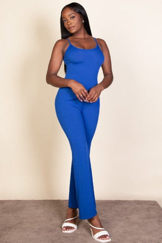 Model wearing a blue ribbed sleeveless wide leg jumpsuit with spaghetti straps, crafted from stretch rib knit fabric.