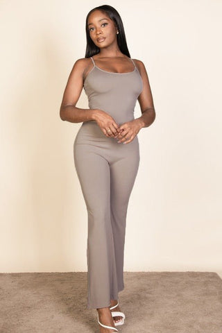 Model wearing a ribbed sleeveless wide leg jumpsuit with spaghetti straps; soft stretch fabric of 95% polyester, 5% spandex.