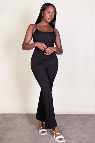 Woman wearing a ribbed sleeveless wide leg jumpsuit with spaghetti straps, made of soft stretch rib knit fabric in black.
