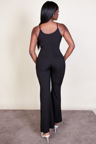 Back view of a woman wearing a ribbed sleeveless wide leg jumpsuit with spaghetti straps, made from stretch rib knit fabric in black.