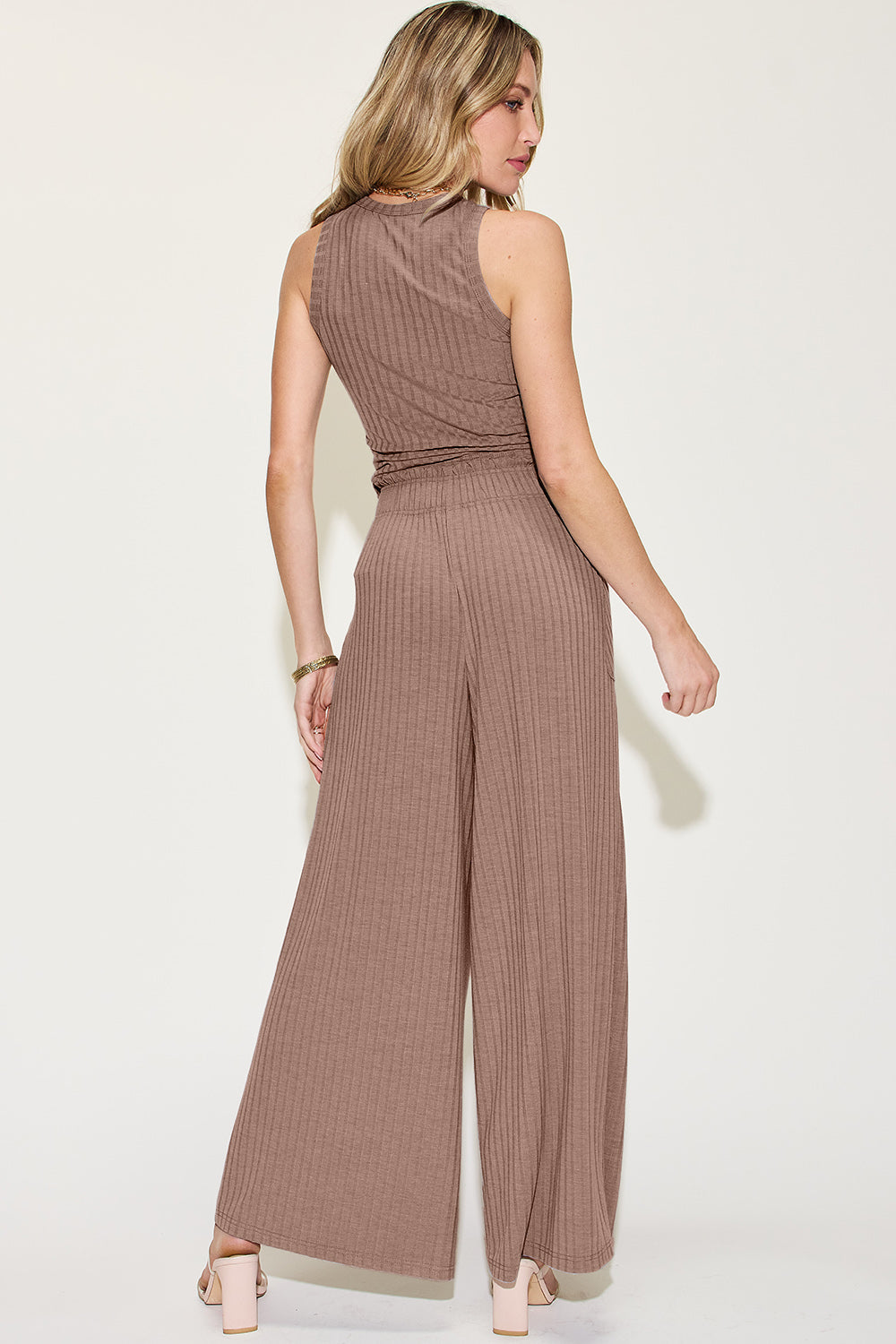 Woman wearing ribbed tank and wide leg pants set in taupe, featuring a frill detail and pockets, made of polyester, rayon, and spandex.