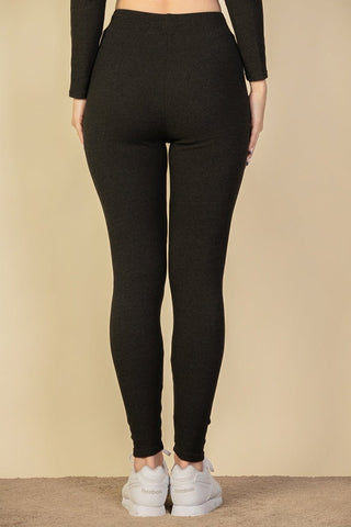 Back view of ribbed tie front leggings in black with elastic band, made from soft, medium weight stretch fabric. Model wearing size S.