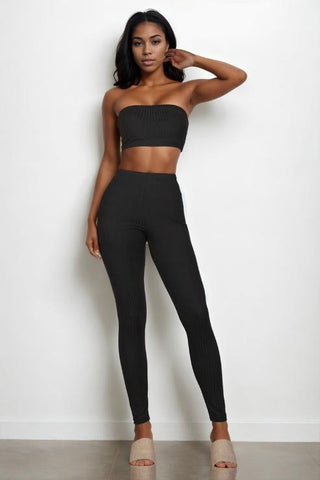 Woman wearing black ribbed tube top and leggings set, featuring tube top and bodycon style, made from 92% polyester and 8% spandex.