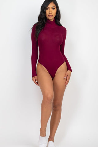 Model wearing a burgundy ribbed turtle neck long sleeve bodysuit, soft and stretchy, made of 92% polyester, 8% spandex.