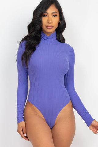 Model wearing royal blue ribbed turtleneck long sleeve bodysuit, soft lightweight knit with high stretch, ideal for stylish layering.