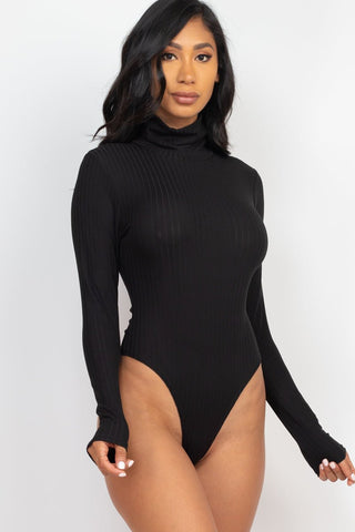 Model wearing black ribbed turtle neck long sleeve bodysuit, made from high-stretch polyester and spandex blend.