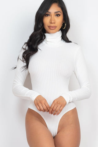 Model wearing white ribbed turtle neck long sleeve bodysuit made from polyester and spandex.