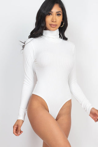 Model wearing a white ribbed turtle neck long sleeve bodysuit made of high stretch rib knit fabric.