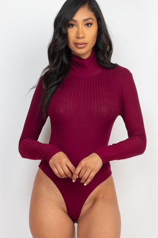 Model wearing a burgundy ribbed turtle neck long sleeve bodysuit, showcasing the high stretch and soft texture of the fabric.