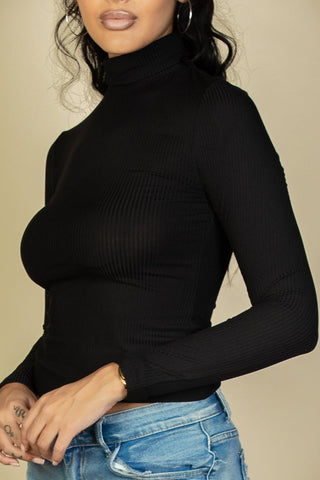 Model wearing black ribbed turtleneck long sleeve top with high stretch, paired with jeans, featuring elegant and casual style.