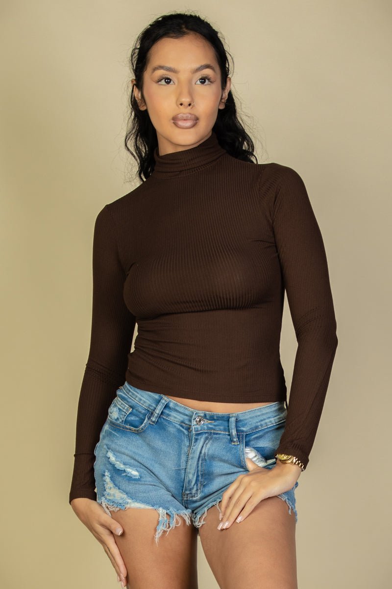 Model wearing a ribbed turtleneck long sleeve top in brown paired with distressed denim shorts, showcasing a stylish casual look.