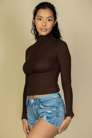 Model wearing ribbed turtleneck long sleeve top in brown with denim shorts, showcasing soft and stretchy high-stretch rib knit fabric.