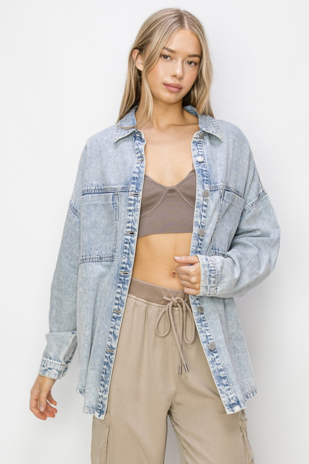 "Woman wearing Risen Button Up Long Sleeve Shacket in light denim with beige pants"