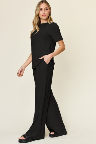 Woman wearing a black round neck short sleeve T-shirt and wide leg pants set, stylish basic two-piece outfit, slightly stretchy fabric.