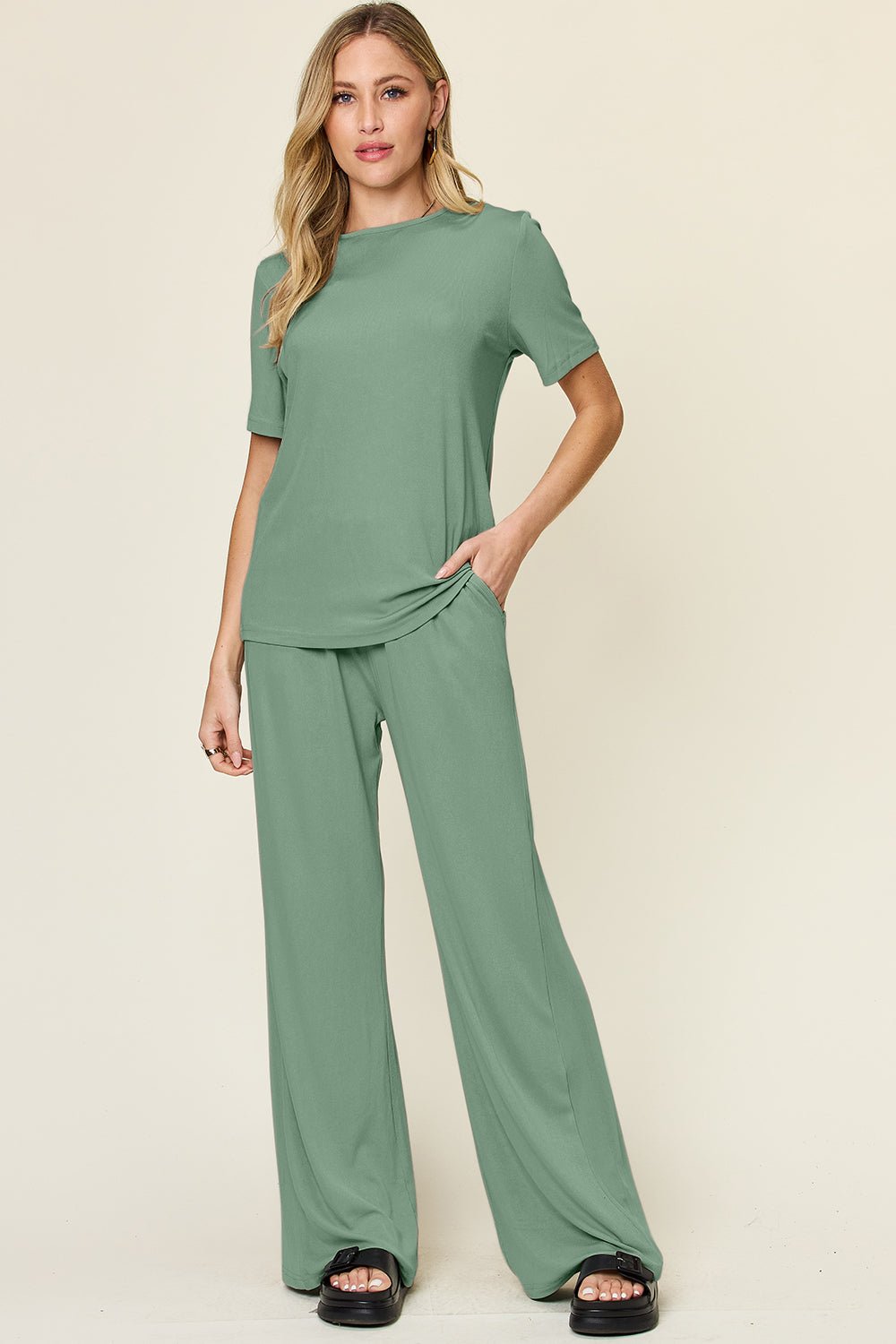 Woman wearing green round neck short sleeve t-shirt and wide leg pants set, casual and slightly stretchy two-piece outfit.