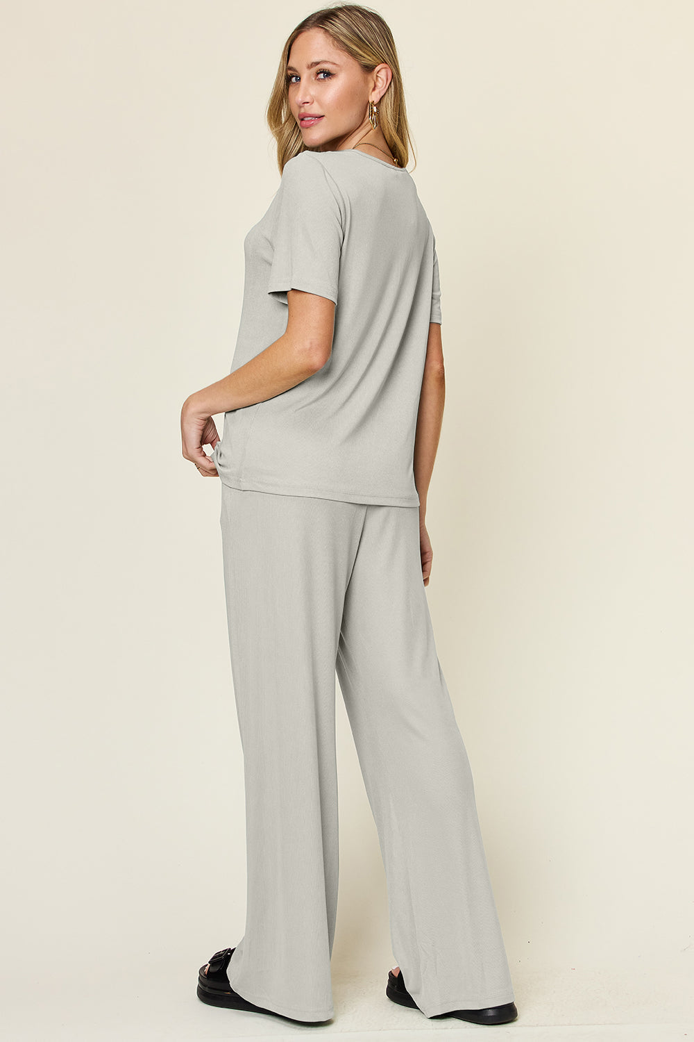 Woman wearing a round neck short sleeve t-shirt and wide leg pants set, showcasing a basic style with slightly stretchy fabric.