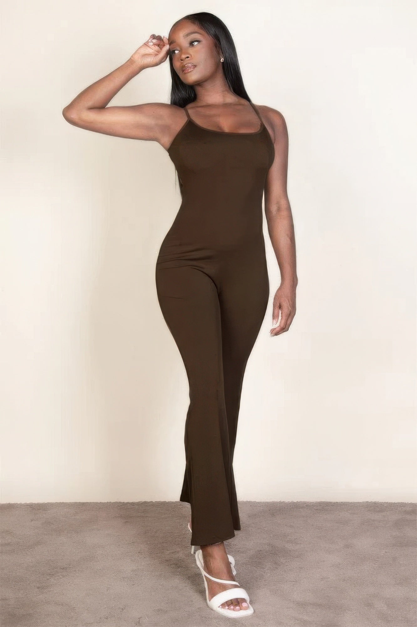 Sleek brown sleeveless jumpsuit with wide-leg pants and spaghetti straps, elegantly showcasing a streamlined silhouette.