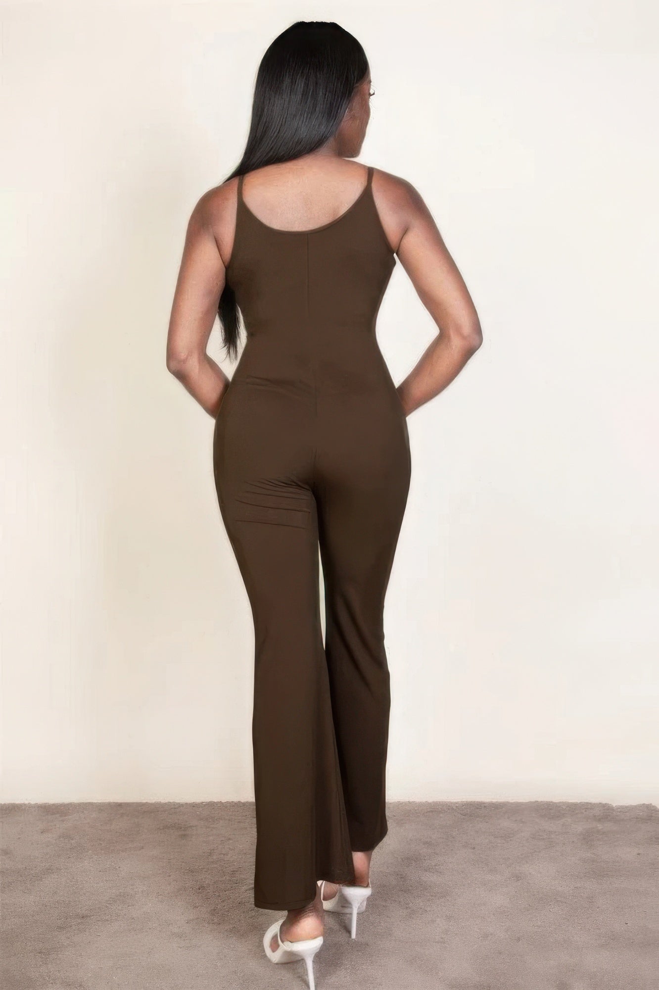 Woman wearing ribbed sleeveless wide-leg jumpsuit in brown, showcasing a sleek and elegant look from the back.