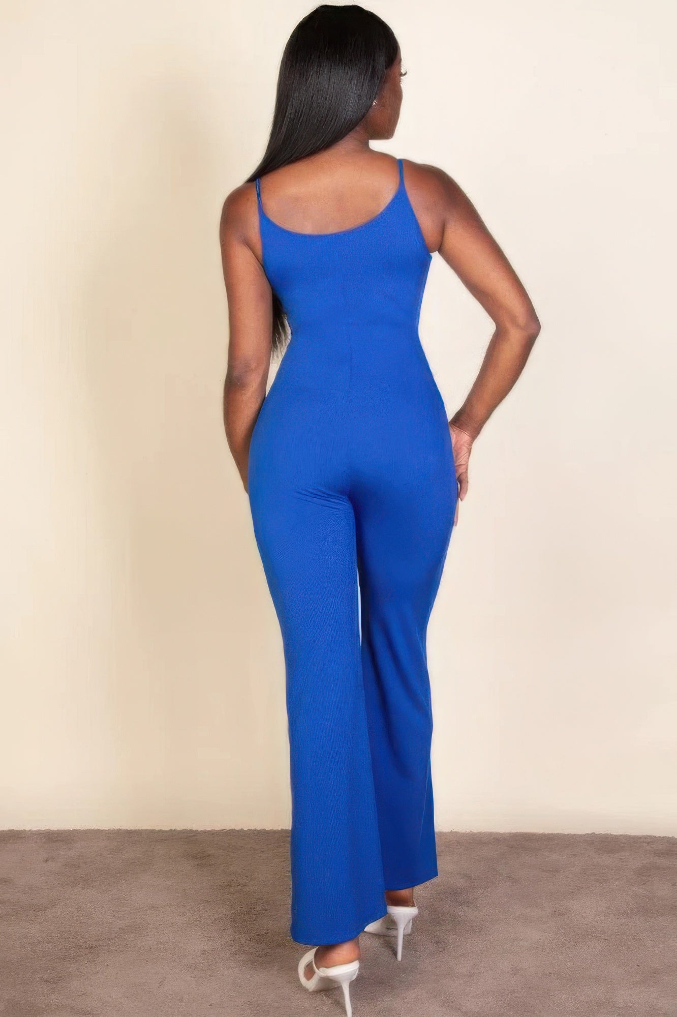 Woman wearing royal blue ribbed sleeveless wide-leg jumpsuit, highlighting sleek and chic style from back view