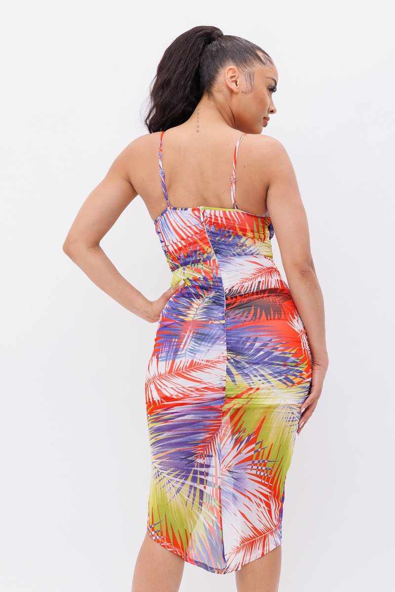 Woman wearing vibrant orange and green printed mesh dress with spaghetti straps, showcasing a colorful and stylish summer look.