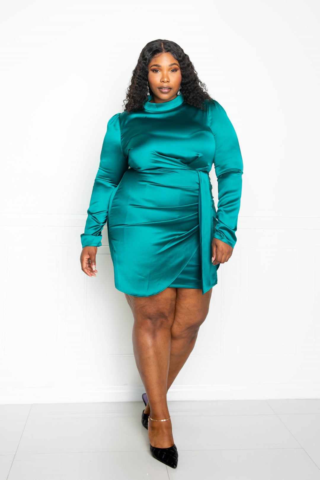 Plus-size model wearing teal satin mock neck rouched mini dress, showcasing elegant and stylish design.