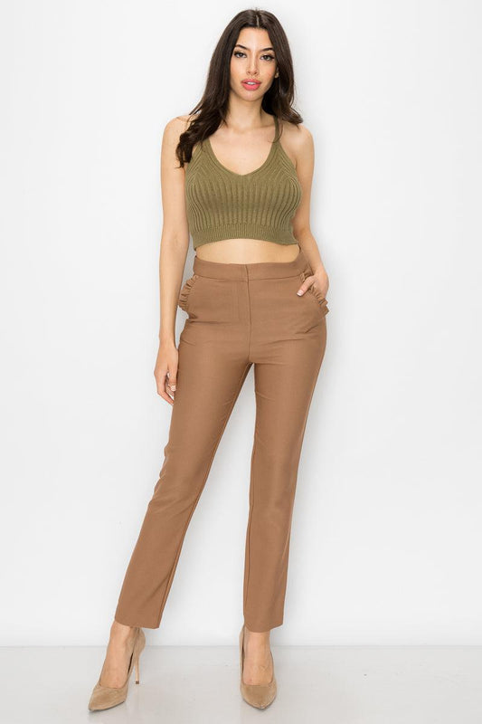 Woman wearing olive ribbed scoop neck tank top with cami straps and cropped hem, paired with brown pants and heels.