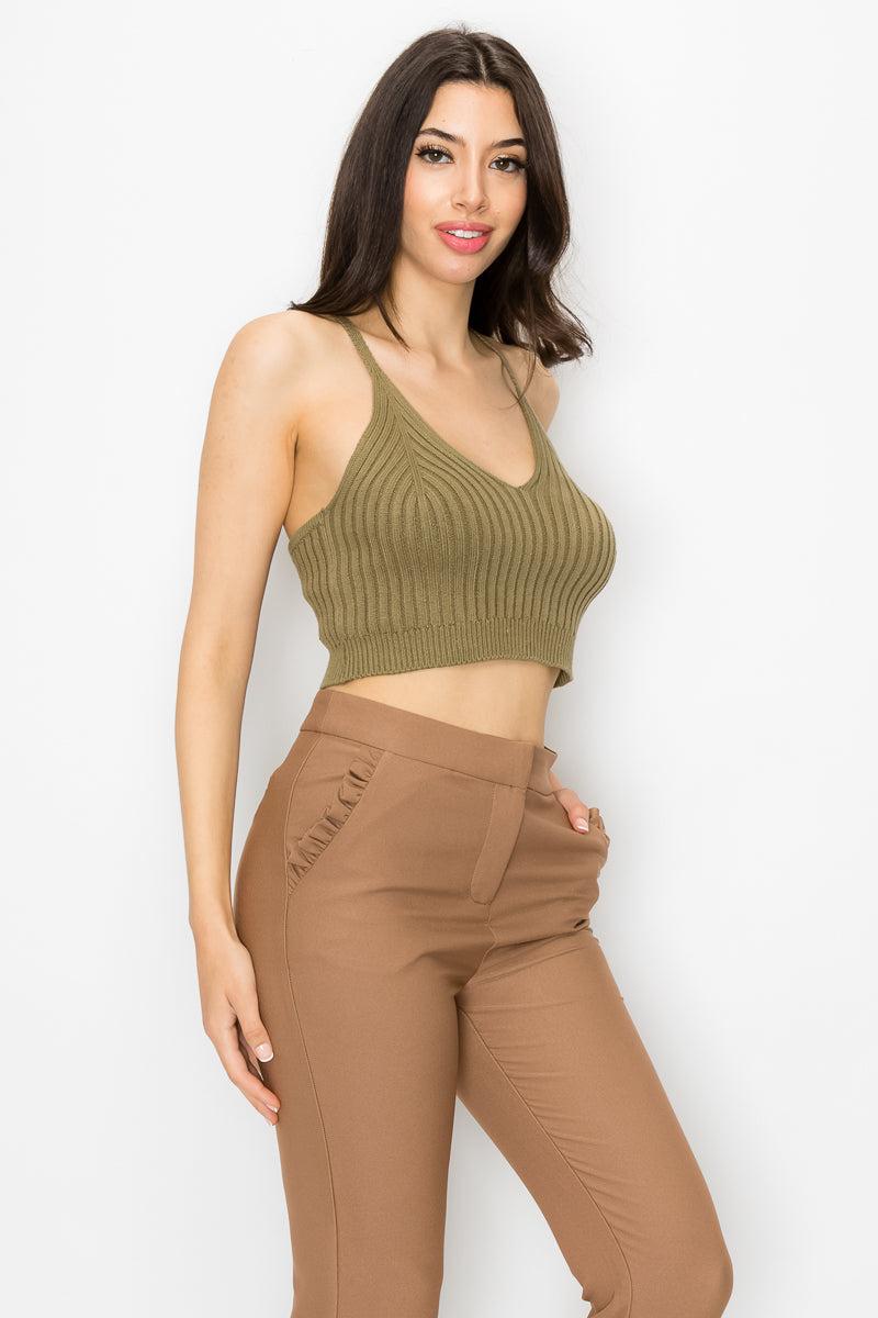 Woman wearing olive scoop neck ribbed tank top with cami straps and cropped hem, styled with brown high-waisted pants.