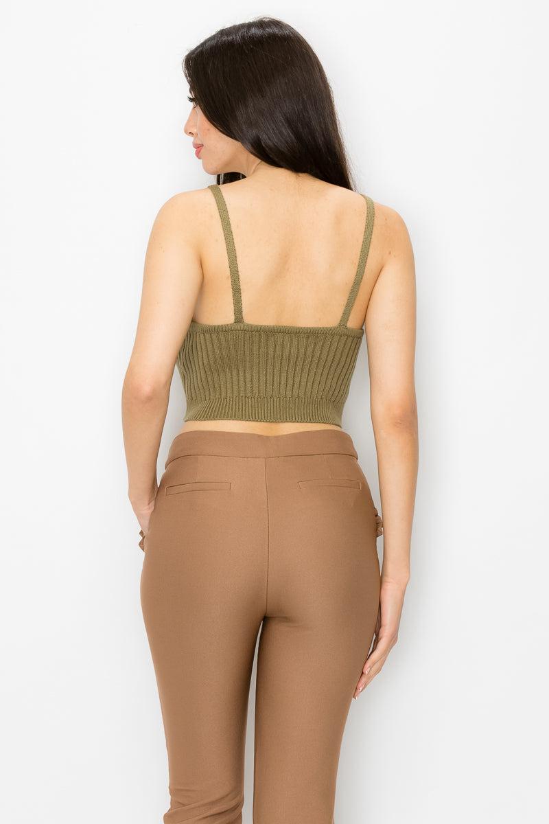 Woman wearing olive scoop neck ribbed tank top with cami straps and square cut-back, paired with brown pants.