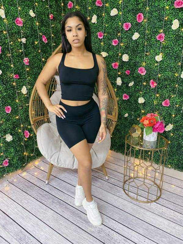 Woman wearing My Summer Tank Biker Short Set, seamless scoop neck crop top and biker shorts, posed against a floral wall.