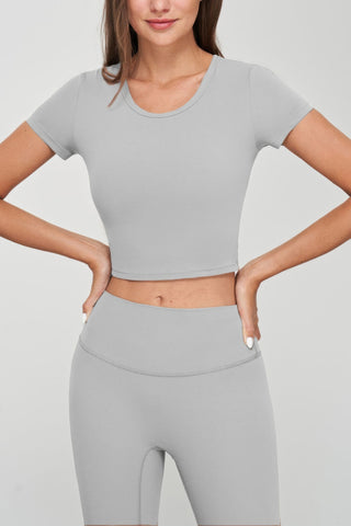 Grey seamless short sleeve crop tee, form-fitting and stylish, perfect for pairing with high-waisted bottoms. Comfortable stretch fabric.
