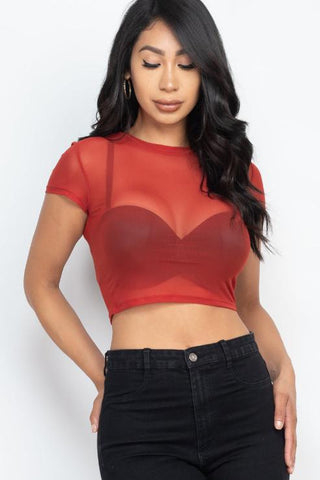 Model wearing a sexy mesh sheer short sleeve red crop top with black jeans, perfect for a trendy and fashionable look.