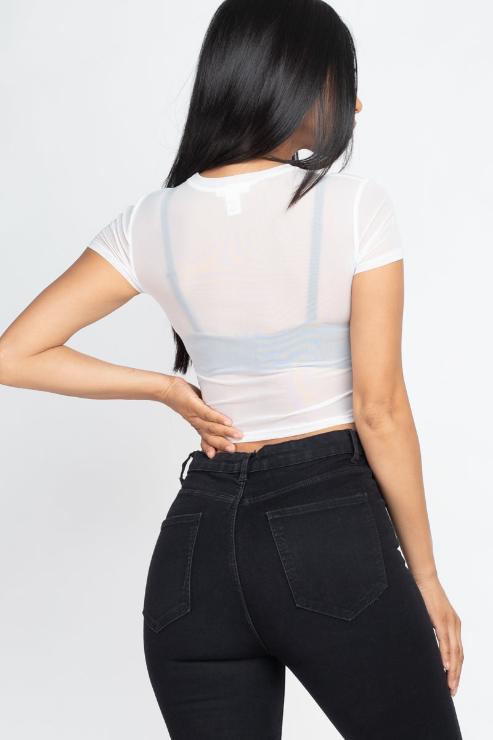 Back view of model wearing a sexy mesh sheer short sleeve crop top in white, showcasing lightweight fabric; paired with black jeans.