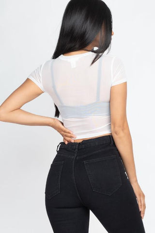 Back view of model wearing a sexy mesh sheer short sleeve crop top in white, showcasing lightweight fabric; paired with black jeans.