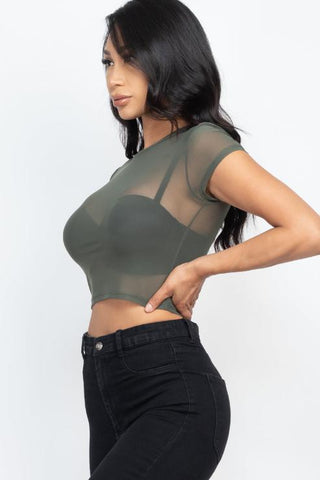 Woman wearing sexy mesh sheer short sleeve crop top in green, paired with black jeans. Soft, lightweight fabric, polyester and spandex.