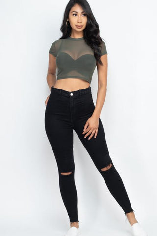 Model wearing a sexy mesh sheer short sleeve crop top in army green, paired with high-waisted black jeans. Perfect for trendy outings.