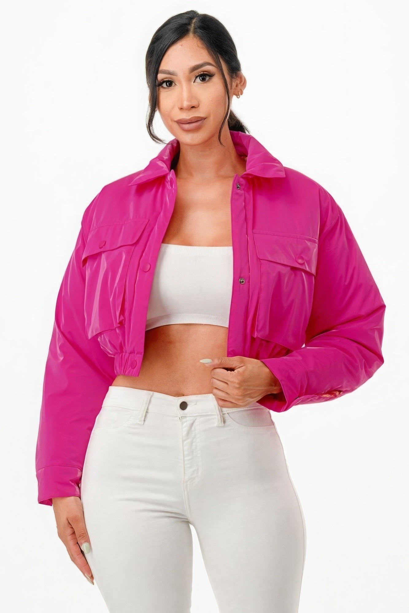 Woman wearing a shiny pink cropped puffer bomber jacket with a relaxed fit and snap button closure.