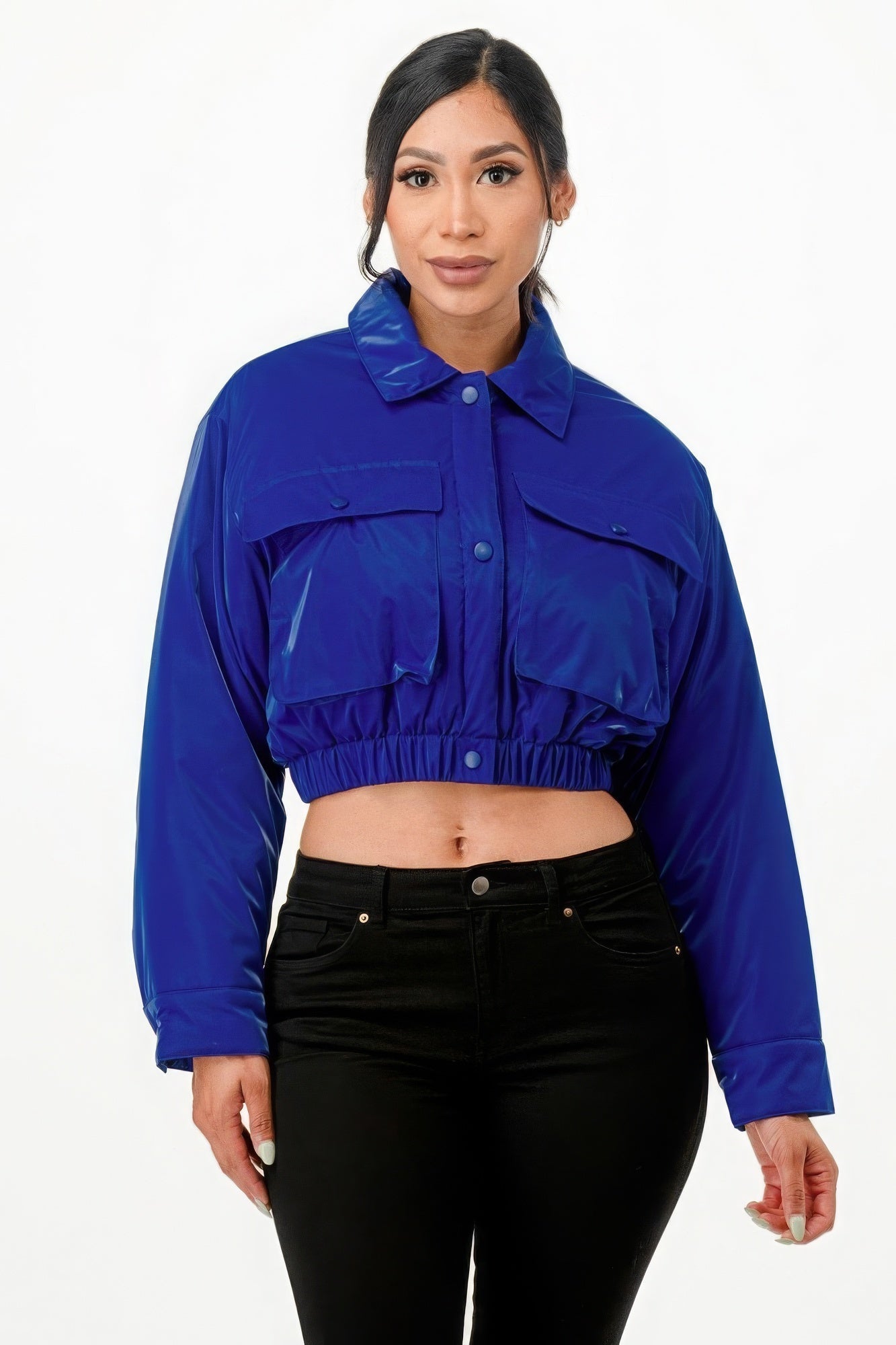 Royal blue shiny cropped puffer bomber jacket with snap button closure and front pockets, worn by model.