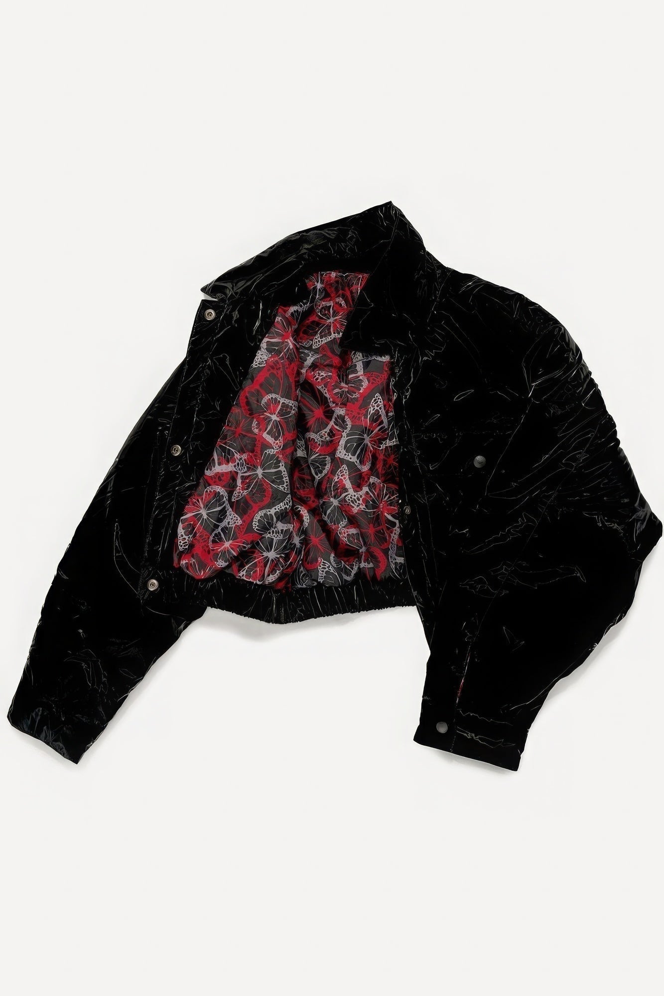 Black velvet jacket with red patterned lining, open layout, highlighting unique interior design and texture.