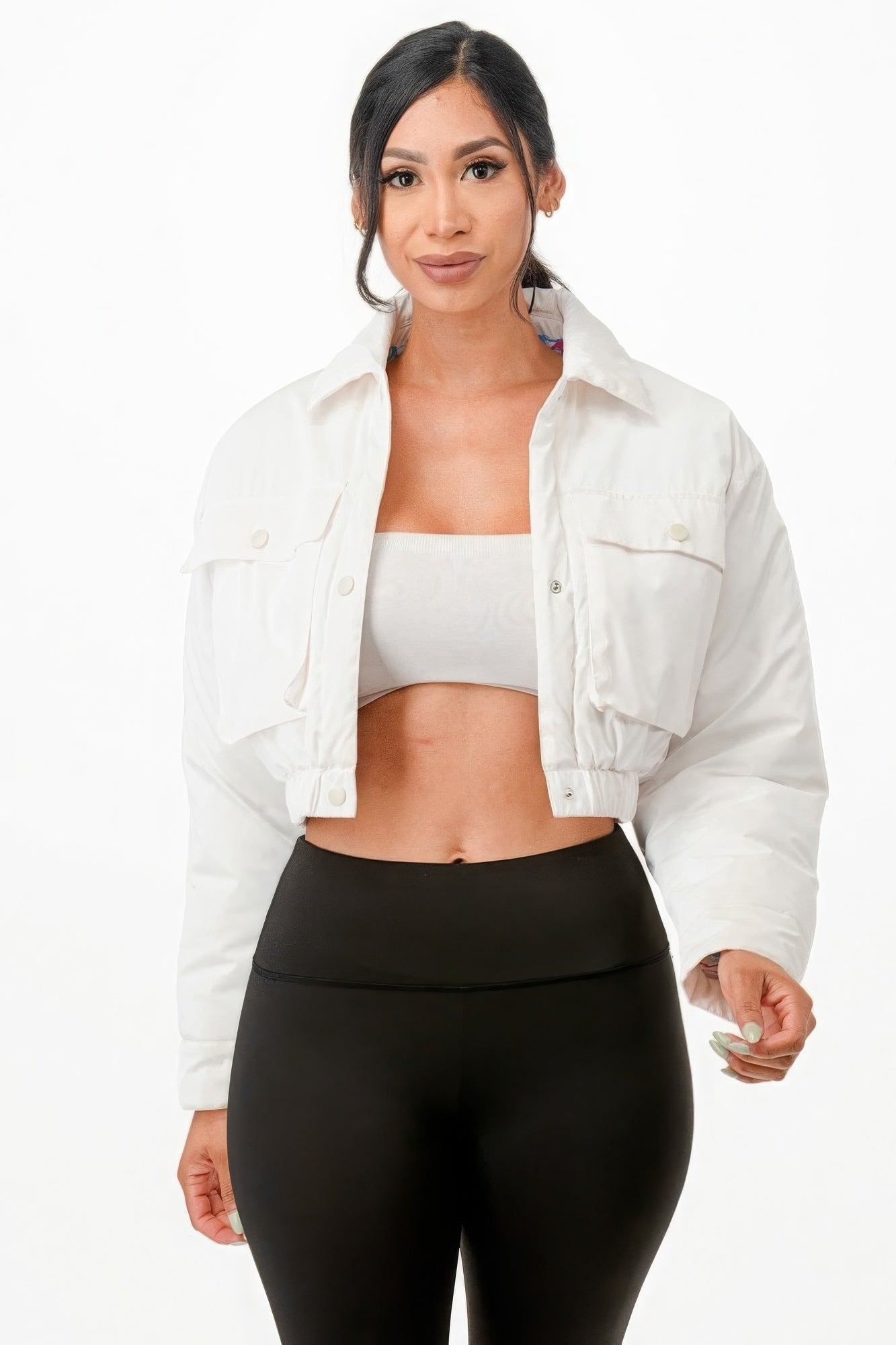 Woman wearing cropped white puffer bomber jacket with relaxed fit and two front pockets.