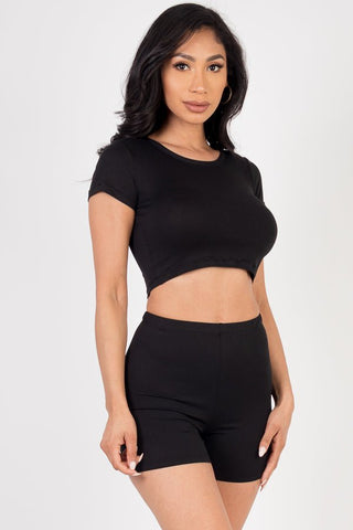Model wearing a black short sleeve crop top and shorts set made of soft, lightweight, high-stretch jersey fabric; perfect for casual wear.