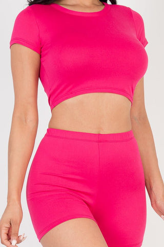 Woman wearing a pink short sleeve crop top and shorts set made from soft, lightweight jersey fabric with high stretch.