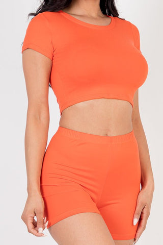 Model wearing orange short sleeve crop top and shorts set, made from soft, high-stretch jersey fabric with polyester and spandex blend.
