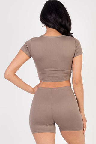 Model wearing taupe short sleeve crop top and shorts set made of soft, high stretch jersey fabric with 92% polyester and 8% spandex.