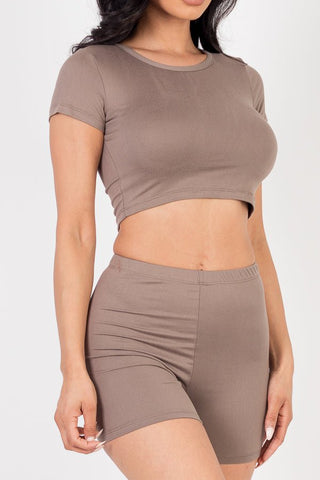 Model wearing a brown short sleeve crop top and shorts set made from soft, high stretch jersey fabric, featuring a fitted and stylish look.