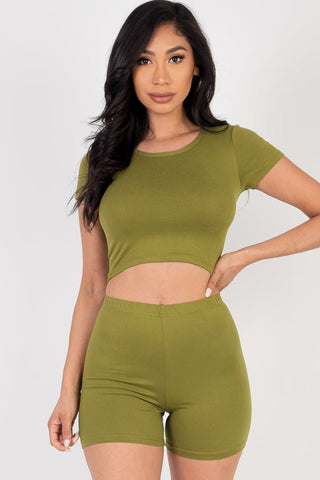 Woman wearing olive green short sleeve crop top and shorts set made from lightweight, high-stretch jersey fabric, perfect for casual wear.