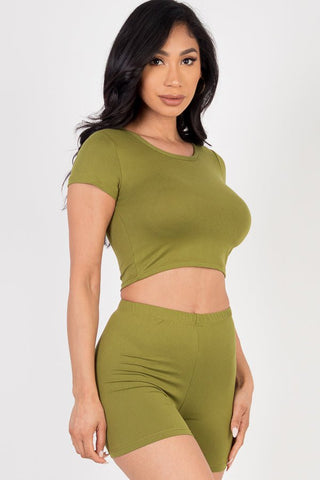 Model wearing olive green short sleeve crop top and shorts set; soft, high stretch, jersey fabric; 92% polyester, 8% spandex.