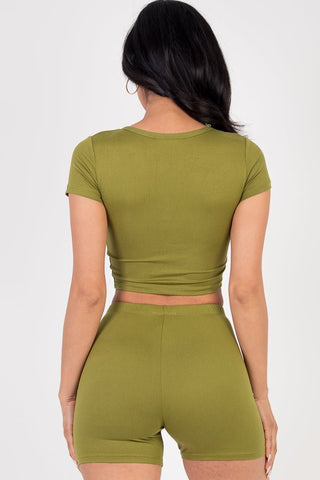 Model wearing olive green short sleeve crop top and shorts set, showcasing back view. High stretch, lightweight jersey fabric.