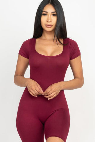 Model wearing burgundy short sleeve scoop neck bodycon romper, showcasing stretchy fabric for a tight yet comfortable fit.
