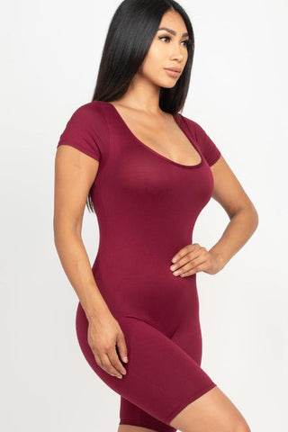 Woman wearing a maroon short sleeve scoop neck bodycon romper, showcasing a tight yet comfortable fit made from 92% polyester and 8% spandex.